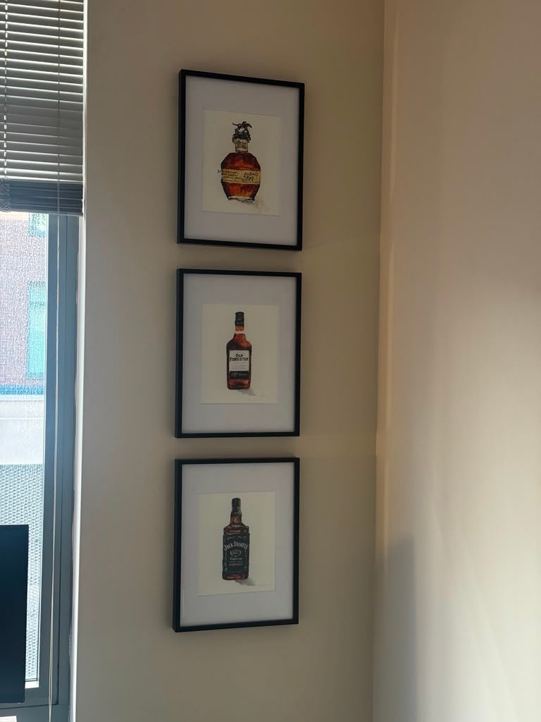 Three framed pictures hanging in corner
