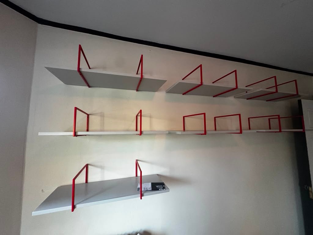 White wall shelves with red brackets