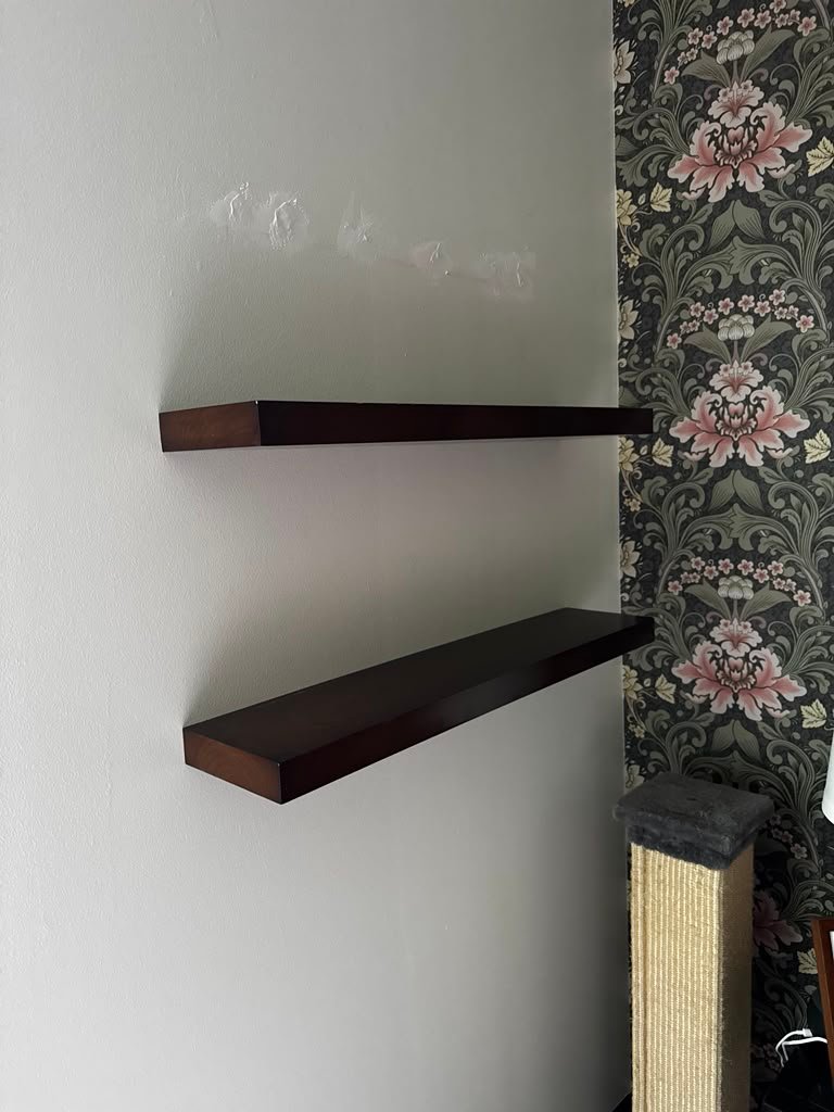 Two floating shelves beside wallpaper