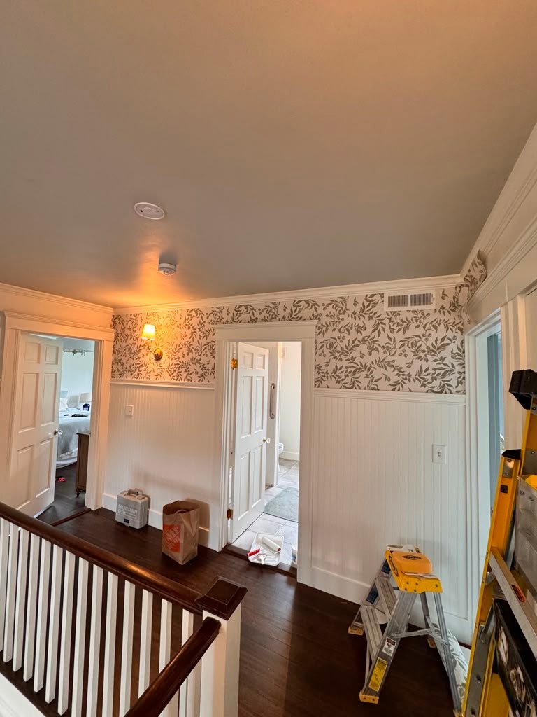 Hallway wallpaper installation above wainscoting