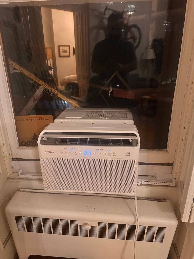 Window AC installation at night